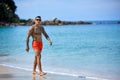 Athletic tattooed guy walking at the the tropical beach Royalty Free Stock Photo