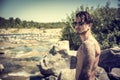 Athletic shirtless young man outdoor at river or water stream Royalty Free Stock Photo