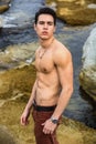 Athletic shirtless young man outdoor at river or water stream