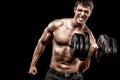 Athletic shirtless young sports man - fitness model holds the dumbbell in gym. Copy space fore your text. Royalty Free Stock Photo