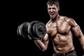 Athletic shirtless young sports man - fitness model holds the dumbbell in gym. Copy space fore your text. Royalty Free Stock Photo