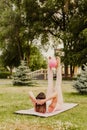 athletic, slender woman in pink clothes and small rubber ball doing Pilates on pink mat at dawn in park in summer Royalty Free Stock Photo