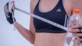 Athletic slim woman measuring her waist by measure tape after a diet over white background, editorial Royalty Free Stock Photo