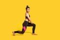 Athletic slim young woman with hair bun in tight sportswear doing sport lunge exercise, standing one knee Royalty Free Stock Photo