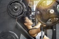 Athletic sport girl doing workout with incline barbell bench press in gym