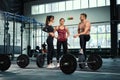 Athletic sport male athlete communicates with fit girls after training in hardcore gym. Fitness healthy man and woman tired after Royalty Free Stock Photo