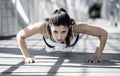 Athletic sport woman doing push up before running in urban training workout