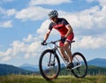 Athletic sportsman cyclist in professional sportswear and helmet riding cross country bike Royalty Free Stock Photo