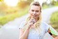 Athletic sporty woman eating protein bar after jogging in park Royalty Free Stock Photo