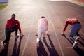 Athletic sprinters at starting position ready for race on racetrack