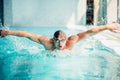 Athletic swimmer swims in butterfly style Royalty Free Stock Photo