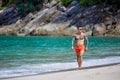 Athletic tattooed guy walking at the the tropical beach Royalty Free Stock Photo