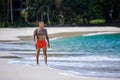 Athletic tattooed guy walking at the the tropical beach Royalty Free Stock Photo