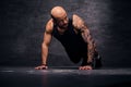 Sporty, shaved head sporty male doing push ups.