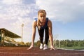 Athletic teenage girl in start position on track. Concept of moving forward. Royalty Free Stock Photo