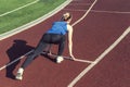 Athletic teenage girl in start position on track. Concept of moving forward. Royalty Free Stock Photo