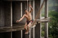 Athletic topless man walking on a slackline on rainy day