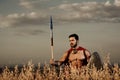 Athletic warrior like spartan among grass in field. Royalty Free Stock Photo