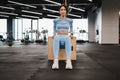 Athletic woman in blue sportswear doing triceps exercises on wooden crossfit jump box at gym. Royalty Free Stock Photo