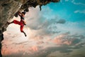 Athletic Woman climbing on overhanging cliff rock with sunrise sky background Royalty Free Stock Photo