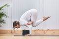 Athletic woman doing the advanced yoga posture Crow pose, kakasana