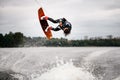 athletic woman doing flips and jumping over the water on wakeboarding board Royalty Free Stock Photo
