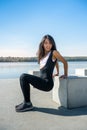 Athletic  woman doing squatting exercise in sunny park near the lake. Concept of wellness and healthy lifestyle Royalty Free Stock Photo