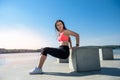 Athletic  woman doing squatting exercise in sunny park near the lake. Concept of wellness and healthy lifestyle Royalty Free Stock Photo