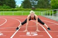 Athletic woman doing straddle stretches on track