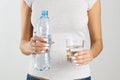 Athletic woman holding a bottle and a glass of water in her hands. Healthy lifestyle concept Royalty Free Stock Photo