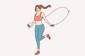 Athletic woman jumping on skipping rope for fitness, doing physical exercises, dressed in sportswear Royalty Free Stock Photo