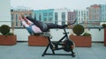 Athletic woman makes twine training routine on spinning stationary bike on house roof, weight loss Royalty Free Stock Photo