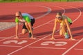 Athletic woman and man on the track of the stadium preparing for the start, starting to run