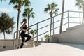 Athletic woman is running on concrete stairs during her summer workout Royalty Free Stock Photo