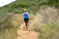 Athletic woman running on dirt trail outside