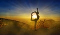 Athletic woman silhouette on a cliff, yoga pose at sunset, meditation in nature Royalty Free Stock Photo