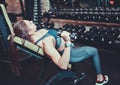 Athletic woman in sportswear doing a dumbbell press on inclined bench at gym. Side view. Royalty Free Stock Photo