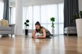 Athletic woman in sportswear doing fitness stretching exercises at home in the living room. Sport and recreation concept. Home Royalty Free Stock Photo