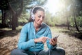 Athletic woman before start running setting up her smart phone a