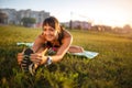 Athletic woman stretching her hamstring, legs exercise training fitness before workout outside with headphones listening music. Royalty Free Stock Photo