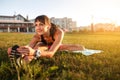 Athletic woman stretching her hamstring, legs exercise training fitness before workout outside with headphones Royalty Free Stock Photo