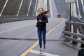 Athletic woman warms up on countryside bridge, jogging. Healthy lifestyle concept