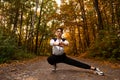 Athletic woman warms up in park before jogging. Healthy lifestyle concept. Sporty woman with hair in ponytail stretching Royalty Free Stock Photo