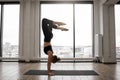 Athletic woman working out yoga in spacious studio