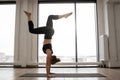 Athletic woman working out yoga in spacious studio