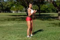 Athletic woman workout with resistance band outdoors. Fitness girl doing exercise for biceps at the park