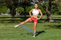 Athletic woman workout with resistance band outdoors. Fitness girl doing exercise for legs at the park Royalty Free Stock Photo