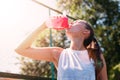 Athletic young blond woman drinks water from sports bottle with cool illuminating water Royalty Free Stock Photo