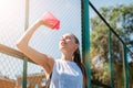 Athletic young blond woman drinks water from sports cup with cool illuminating water Royalty Free Stock Photo