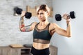 Athletic young blonde woman doing heavy dumbbell exercise for shoulders in the gym. Royalty Free Stock Photo